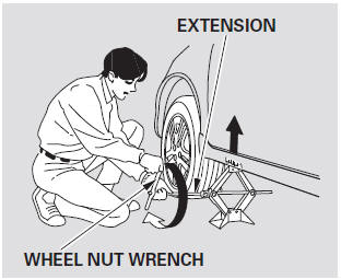 10. Use the extension and the wheel nut wrench as shown to raise the vehicle